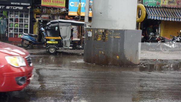 Stock Photo of Rickshaw in Mumbai Rains and Wet Road