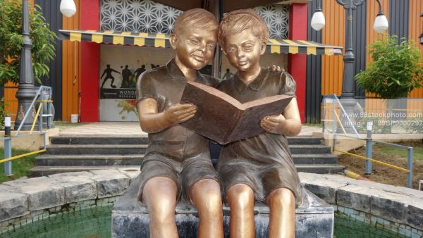 Stock Photo of Statue of two Kids reading book in Park