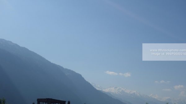 Stock Photo of Sunrays with Hill View with Distant Snow View Hill